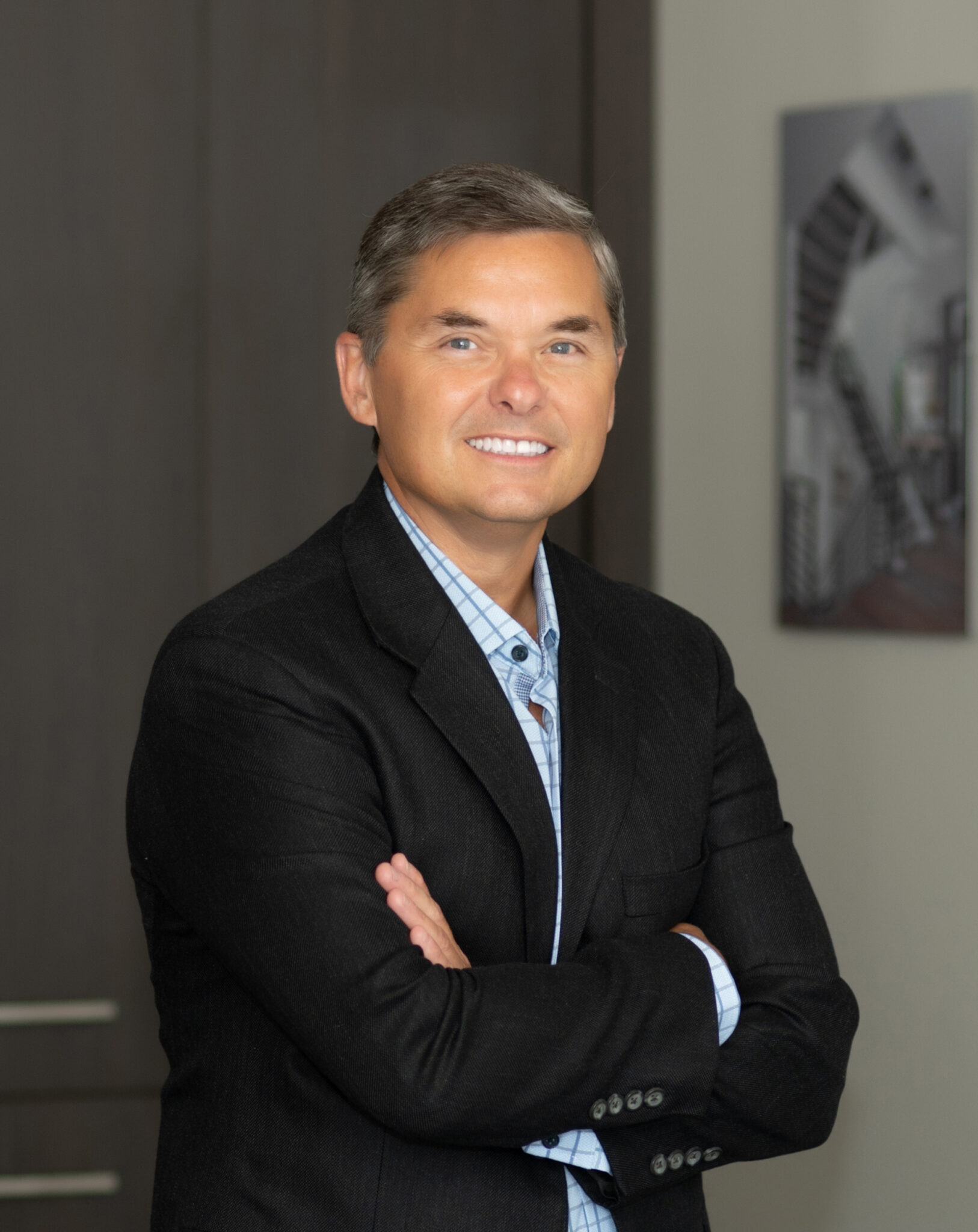 a man wearing a suit and tie smiling at the camera