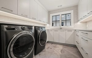 A renovated laundry room with new white cabinets.